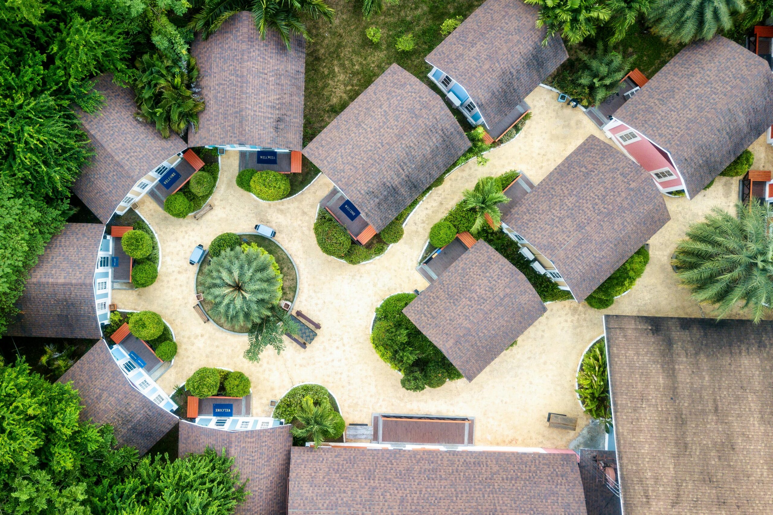 Aerial view of a circular resort layout surrounded by lush greenery in Cambodia.